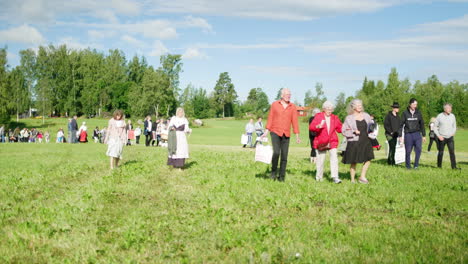 Crowd-of-people-walking-over-a-field-on-a-summer-day-in-the-sun