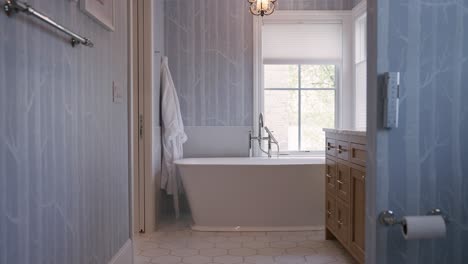 Bathroom-with-blue-wallpaper-and-white-bathtub