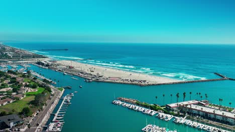 Marina-in-Oceanside-California-drone-view-flying-over-the-boats-and-looking-towards-the-Pacific-Ocean