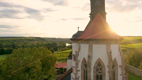 drone-flight-in-front-of-a-church-from-the-bottom-up-to-the-sunset-in-the-middle-of-vineyards
