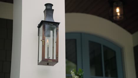 Lit-gas-lantern-hanging-at-front-of-home
