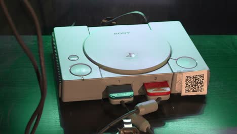 Foto-Del-Paquete-De-Una-Consola-Playstation-1,-Foto-De-Viaje-Con-La-Mano-Derecha