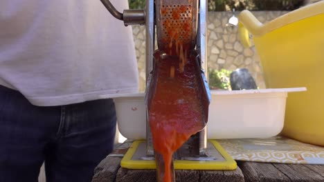 Fresh-pressed-tomato-sauce-coming-out-of-machine