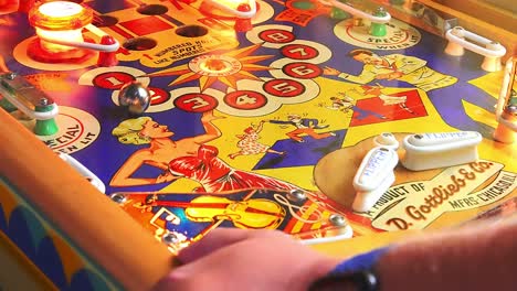 gamer-hand-play-pinball-machine-with-flipper-hit-ball-multiple-time,-close-up-handheld-fixed-shot