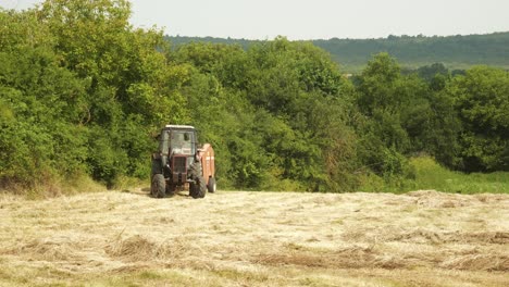 Farm-machinery-working-in-hay-field-during-Bulgaria-summer-harvest