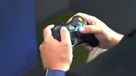 Gamer's-hand-maneuvers-and-play-Xbox-controller,-over-the-shoulder-handheld-close-up-traveling-forward-shot