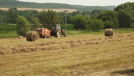Farm-machinery-making-bales-of-hay-during-summer-in-rural-Bulgarian-countryside