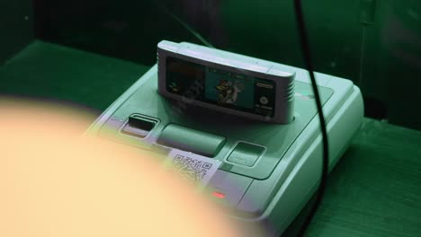 Super-nintendo-console-packshot-with-super-mario-world-game,-traveling-right-handheld-shot