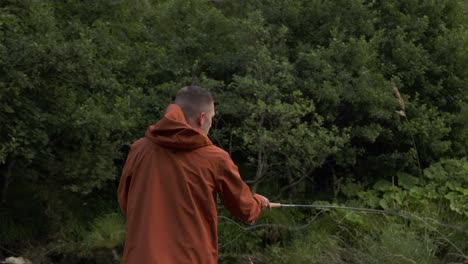 Slow-motion-shot-of-a-fisherman-flyfishing-and-casting-his-line-into-the-river