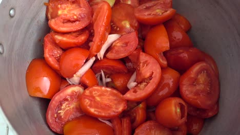 dolly-shot-of-a-pot-filled-with-tomatoes-and-onions