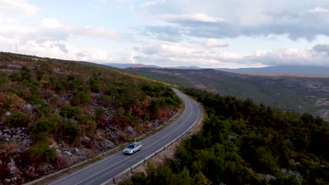 Coche-Plateado-Conduciendo-Por-Una-Carretera-Rural-Solitaria-En-Un-Paisaje-Montañoso-A-Mediados-De-Otoño-En-Bosnia-Y-Herzegovina