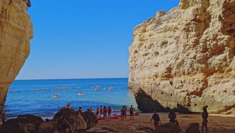 People-Kayaking-In-Beautiful-Summer-Day,-Exploring-Blue-Ocean,-Benagil,-Portugal