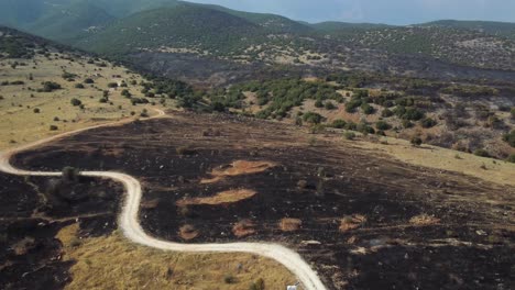 Aerial-of-destroyed-grazing-land-on-a-hill-top-in-the-aftermath-of-wildfires-in-northern-Greece,-August-2023