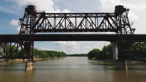 Flying-Through-Rusty-Truss-Bridge-Over-White-River-In-Twin-City-Riverfront-Park,-Arkansas,-USA