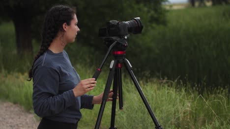 Female-videographer-panning-on-her-tripod-in-the-outdoors