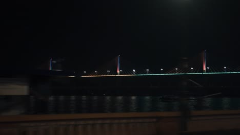Vorbei-An-Einer-Beleuchteten-Schrägseilbrücke-Bei-Nacht