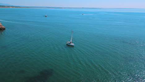 Yachtboot-Im-Meer-Im-Sommer-In-Praia-Dona-Ana-An-Der-Algarve-In-Portugal,-Luftdrohnenansicht