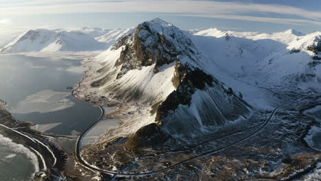 Luftaufnahme-Mit-Blick-Auf-Eine-Schneebedeckte-Bergkette,-Goldene-Winterstunde-In-Südisland