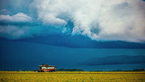Combine-harvester-gather-crops-as-a-storm-blows-in---time-lapse