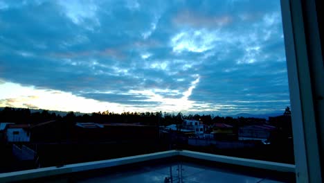 Zeitraffer-Des-Himmels-In-Den-Frühen-Morgenstunden-Mit-Blick-Auf-Den-Horizont-Und-Die-Auf-Die-Wolken-Scheinende-Sonne,-Die-Man-Am-Frühen-Morgen-Aus-Einem-Fenster-Sieht