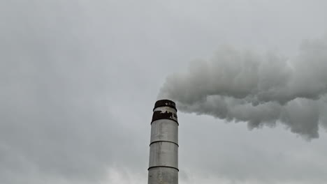 Drone-close-up-to-smoke-going-up-to-the-cloudy-sky-from-the-chimney