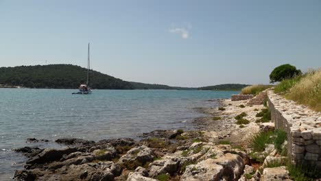 Boat-of-tourists-moored-near-the-historical-Roman-villa-site-at-Medulin,-Croatia