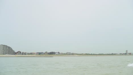 Kommerzielles-Fischerboot-Fährt-In-Der-Nordsee-Vorbei,-Im-Hintergrund-Die-Belgische-Küste-Von-Nieuwpoort---Belgien