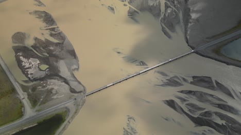 Car-crossing-glacier-river-over-a-long-bridge-in-south-Iceland