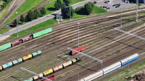 A-red-cargo-wagon-without-a-locomotive-moves-on-the-tracks-at-a-train-station