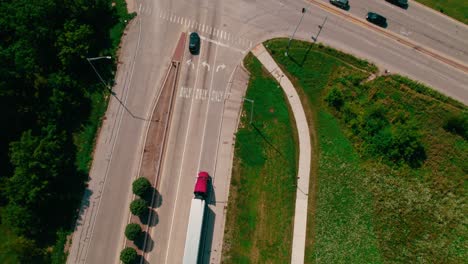 top-down-aerial-of-Two-Red-semi-trucks-and-trailers-stoppimg-on-a-red-light-stop