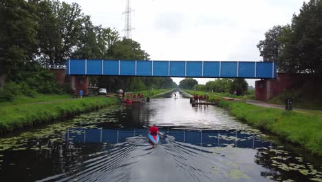People-doing-a-teambuilding-on-the-beverlo-canal-of-Belgium,-kayakking,-supping-and-more