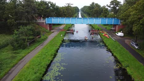 Sportveranstaltung-Unter-Einer-Brücke-Mit-Kajaks-Und-SUPs-Auf-Dem-Beverlo-Kanal