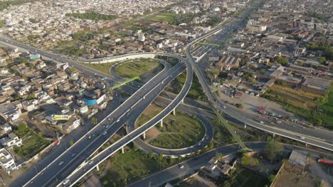 4k:-Drone-flying-over-a-traffic-flyover-with-ongoing-city-traffic-in-Punjab,-Pakistan