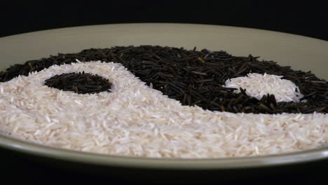 Yin-yang-symbol-made-of-white-and-black-rice-rotates-on-green-plate