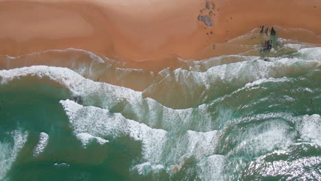 Top-down-aerial-view-of-waves-crashing-on-Cordoama-beach