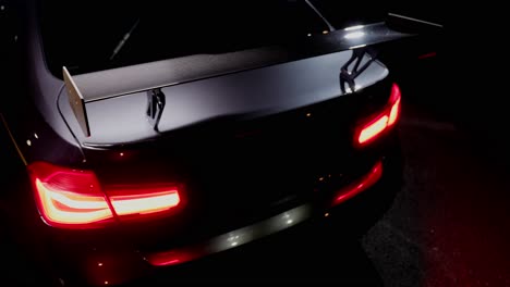 Detail-shot-of-the-back-rear-light-with-spoiler-of-a-sports-car-at-night