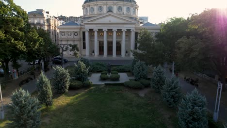 Aerial-View-Of-The-Romanian-Athenaeum-At-Sunrise-In-Bucharest-With-A-Beautiful-Green-Garden-In-Foreground
