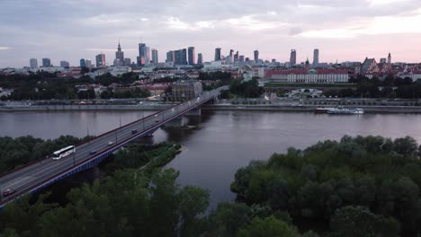 Cinematic-drone-footage-of-Warsaw-skyline-with-vistula-river-and-bridge-filled-with-traffic