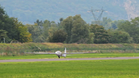 Skillful-pilot-landing-Swift-S-1-glider-runway,-handheld-follow-view