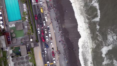 Cars-struggling-in-the-traffic-jam-in-a-south-american-city-coast-street-in-front-of-the-beach-where-are-people-swimming-next-to-an-empty-pool-club