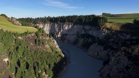 Spectacular-geological-cliff-with-tree-line-and-Rakaia-Gorge-river