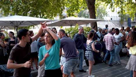 Dancing-Couples-at-Public-Paris-Summer-Festival:-Romantic-Atmosphere-by-the-Shores-of-River-Seine,-French-Culture,-Music,-and-Celebration