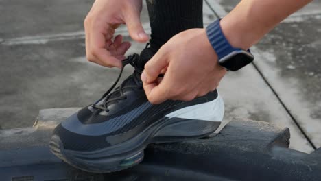 Close-up-of-a-runner-tying-shoes-with-an-Apple-watch-on-the-wrist