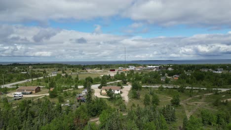 A-moving-aerial-drone-shot-of-a-residential-area-and-Cedar-Lake-in-the-Easterville-and-Chemawawin-Cree-Nation-area-during-the-summer-months-and-overcast-season