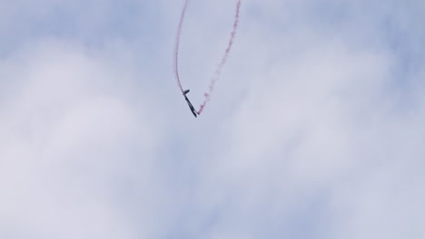 Stunt-Swift-S-1-glider-doing-barrel-rolls-in-sky-with-red-smoke-trail