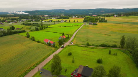 Car-Driving-On-The-Road-In-Typical-Rural-Village-With-Cottages-In-South-Eastern-Norway