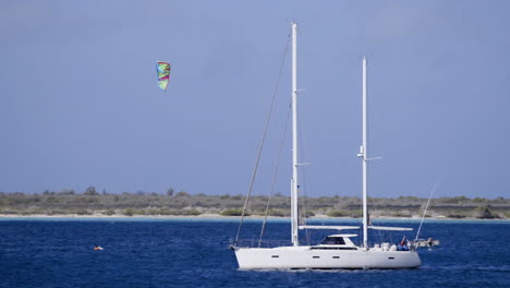 Segelboot-Mit-Drachen-Im-Hintergrund-Auf-Dem-Meer-In-Der-Nähe-Von-Bonaire,-Den-Antillen,-Der-Karibik