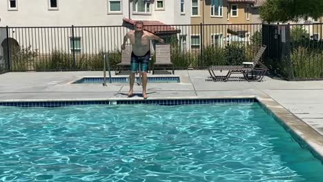 Caucasian-man-jumping-into-community-pool-on-a-hot-summer-day