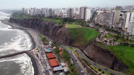 Travelling-tilt-up-shot-showing-a-stunning-panoramic-view-of-southamerican-city-coast-buildings-next-to-green-ravines,-parcs-and-gardens