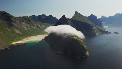 Cinematic-wide-rotating-drone-shot-of-Horseid-Beach-with-turquoise-blue-water,-clouds-moving-over-cliffs
